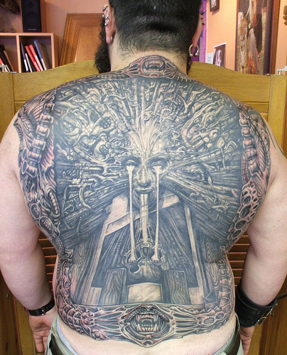 Man's back covered in tattoo