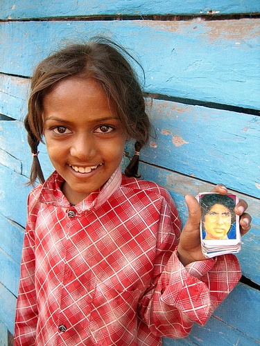In the slum of Ellis Bridge, a girl holds the collectors’ card of Bollywood actor Amitabh Bachchan.